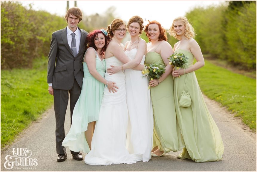 Two brides and bridal party with sage green wedding dresses