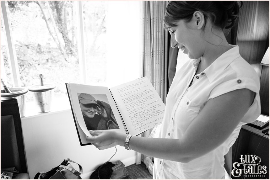 UK Bride looking at photo album of her fiance in a hotel room 