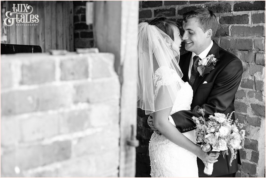 Quirky wedding photography at old green barn of bride holding wild flowers