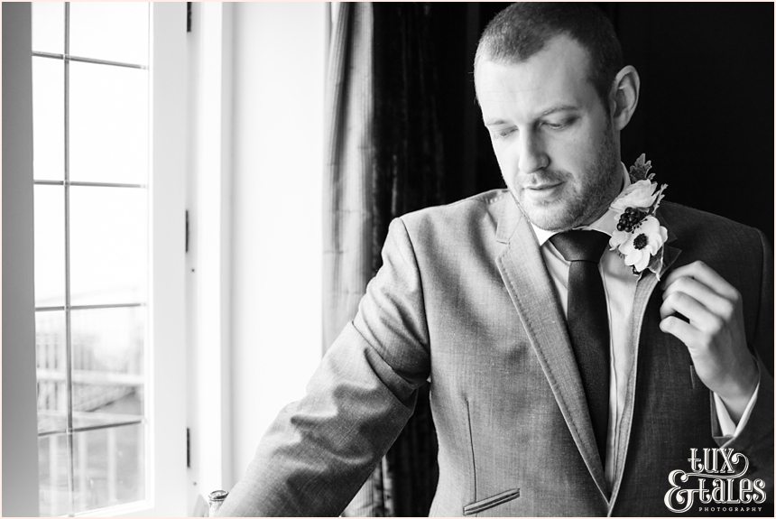 Groom adjusting buttonhole at hogarths hotel wedding