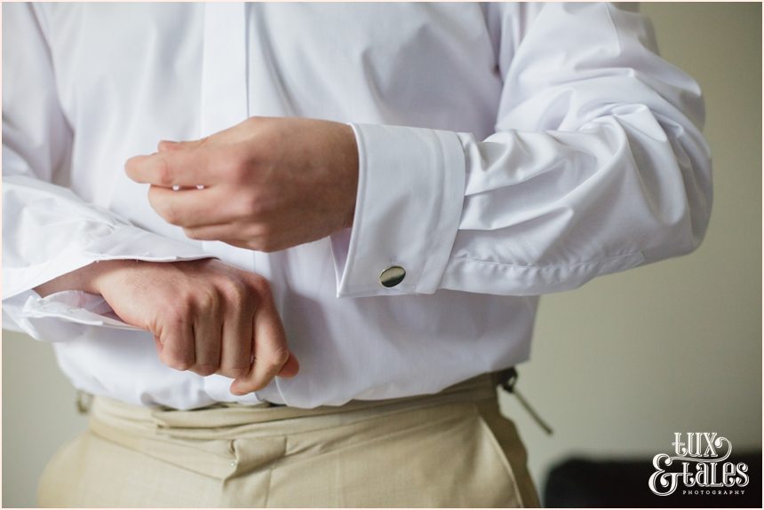 groom fastens cuff links at yorkshire wedding