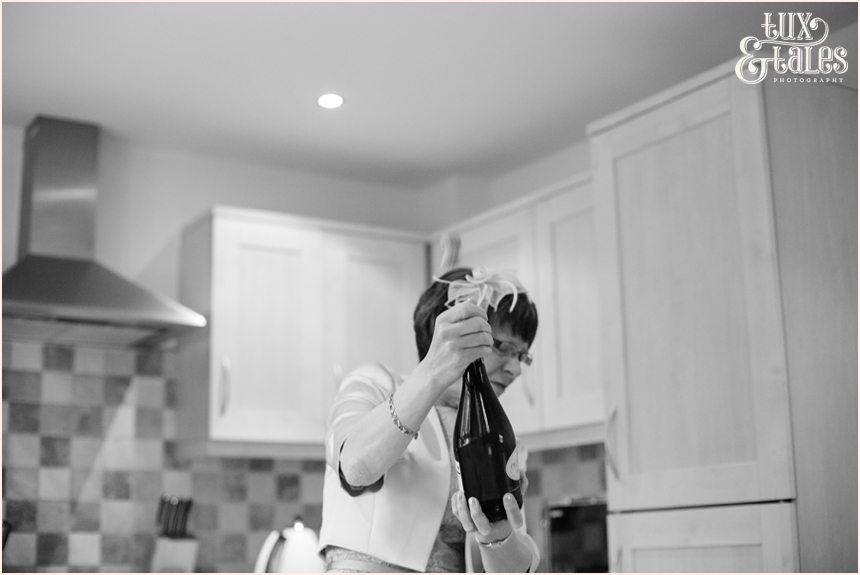 mothe rof the groom pops open champagne at yorkshire wedding
