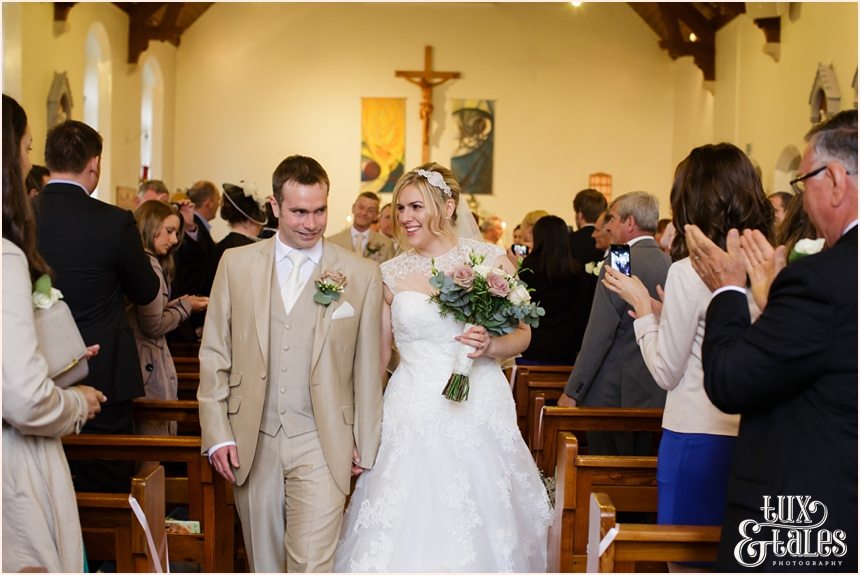 Bride and groom walk up the ailse at yorkshire wedding