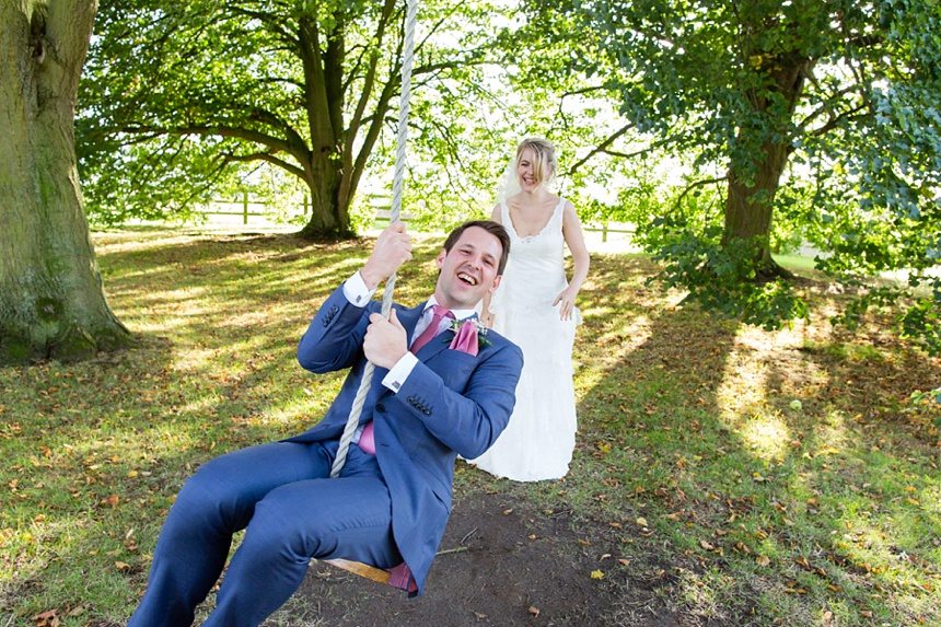 Bride pushing groom on swing Barmbyfield Barn Wedding Photography