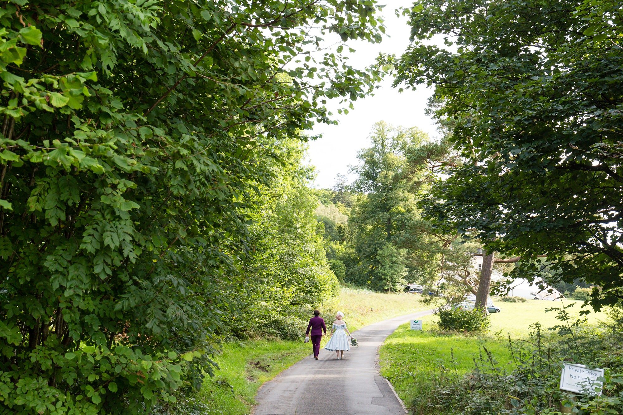 Bride & groom walk up the lane outside of Derwentwater Independent Hostel Wedding