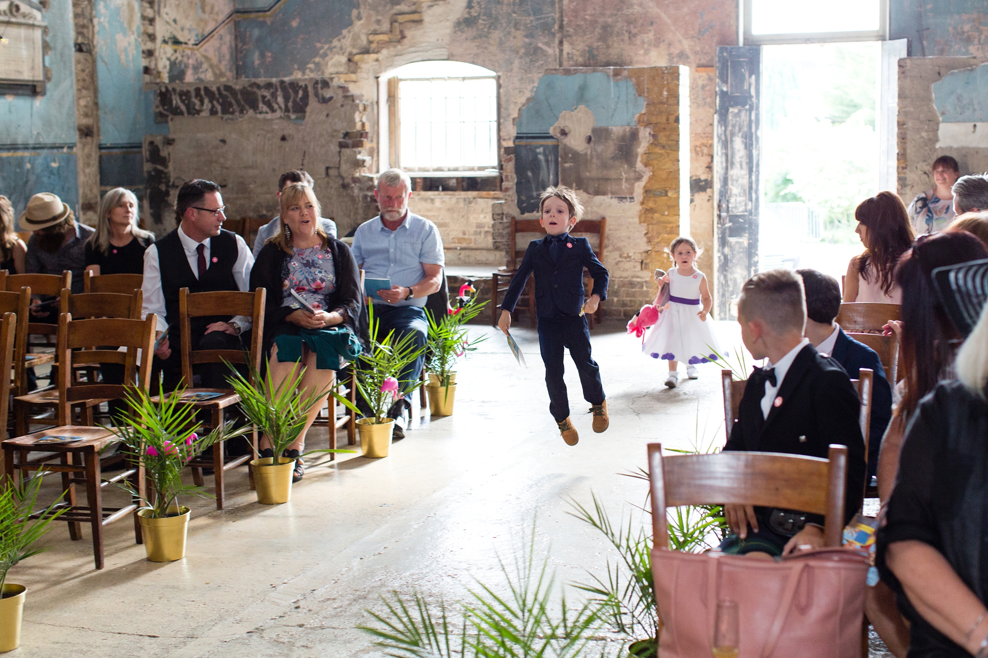 Ring bearer skips up the aisle at wedding at Asylum chapel in London
