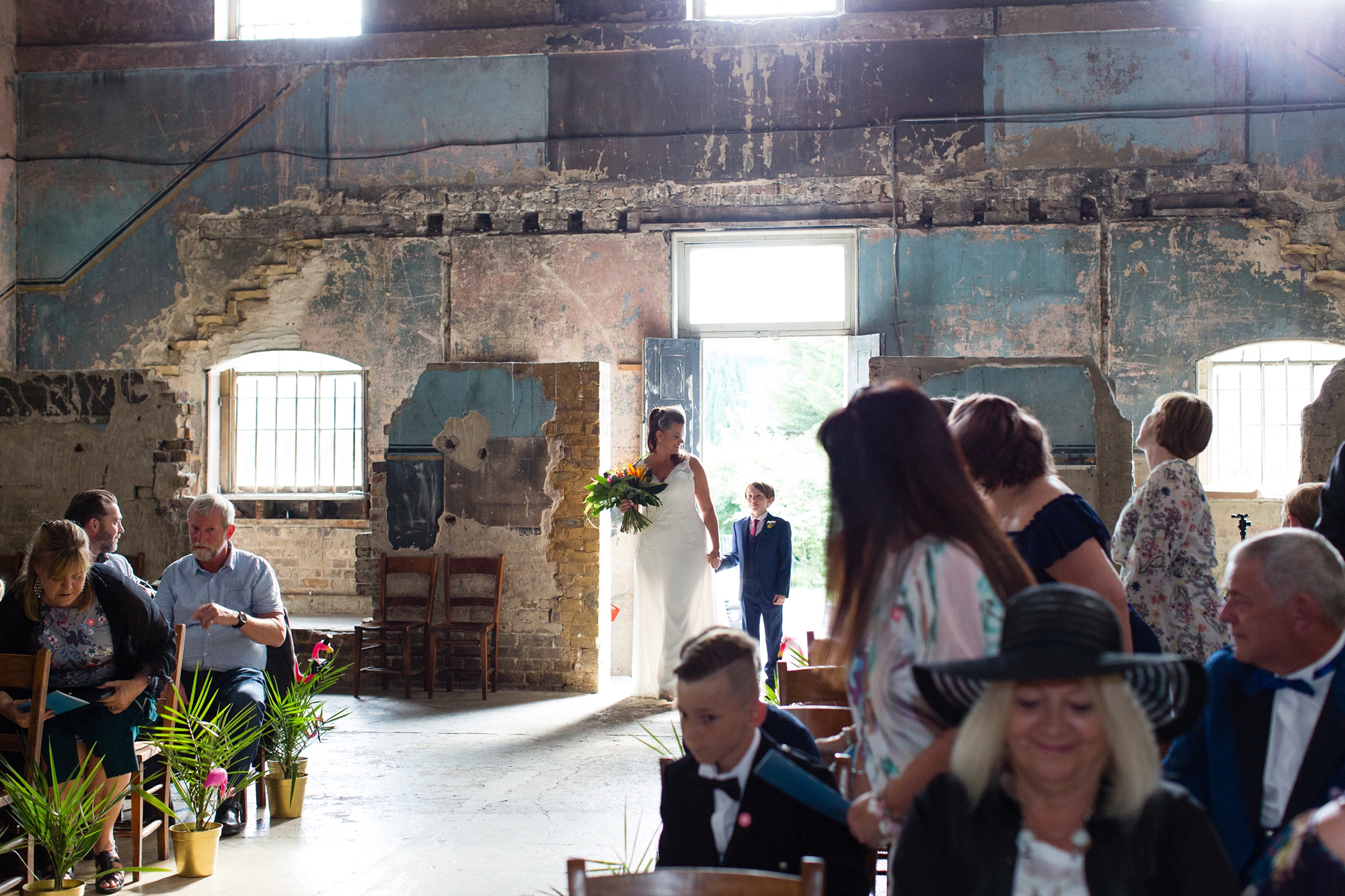 Bride holds son's hand as they walk up aisle at Asylum wedding in London