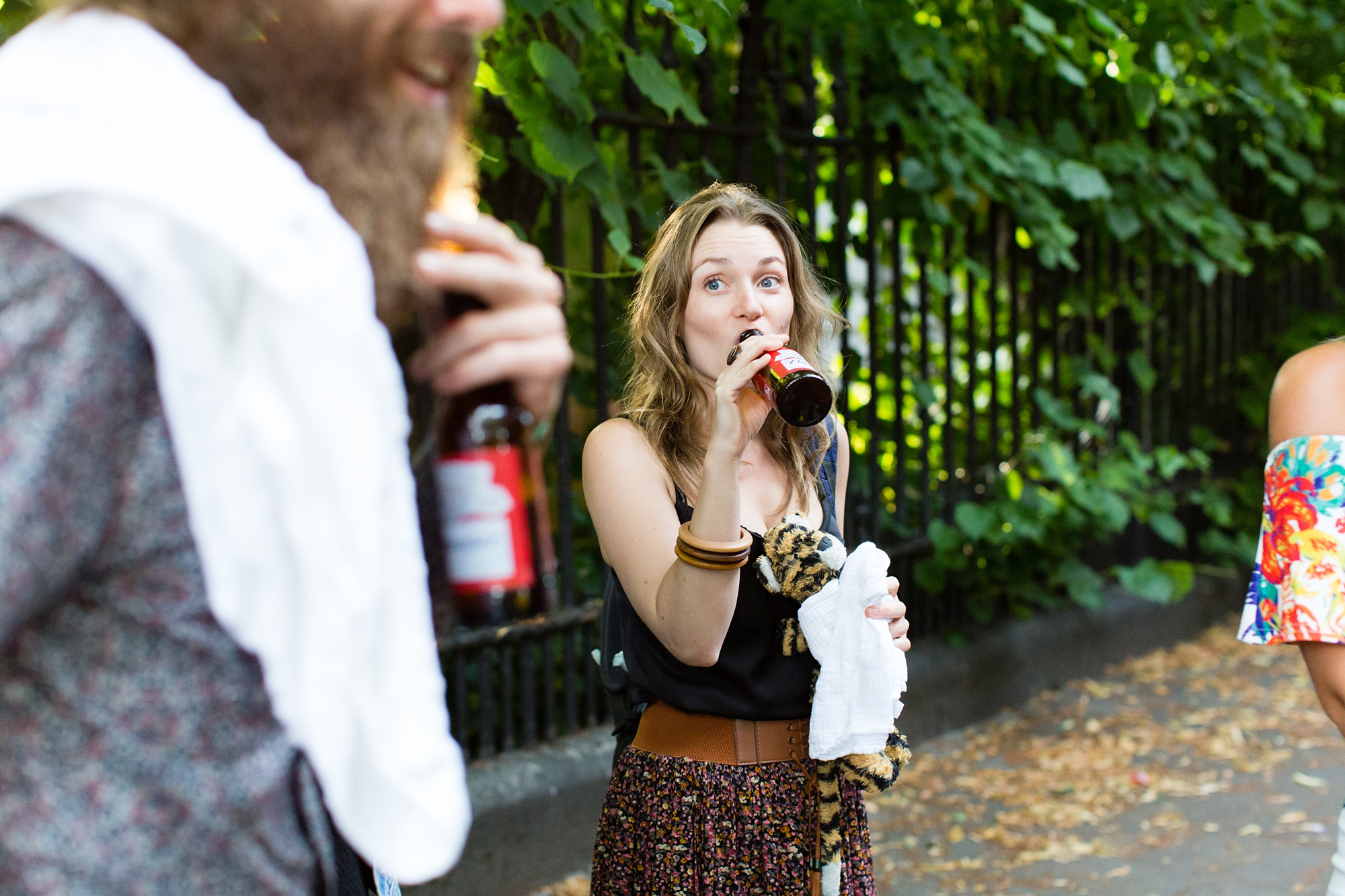 Wedding guest drinks beer from bottle. 