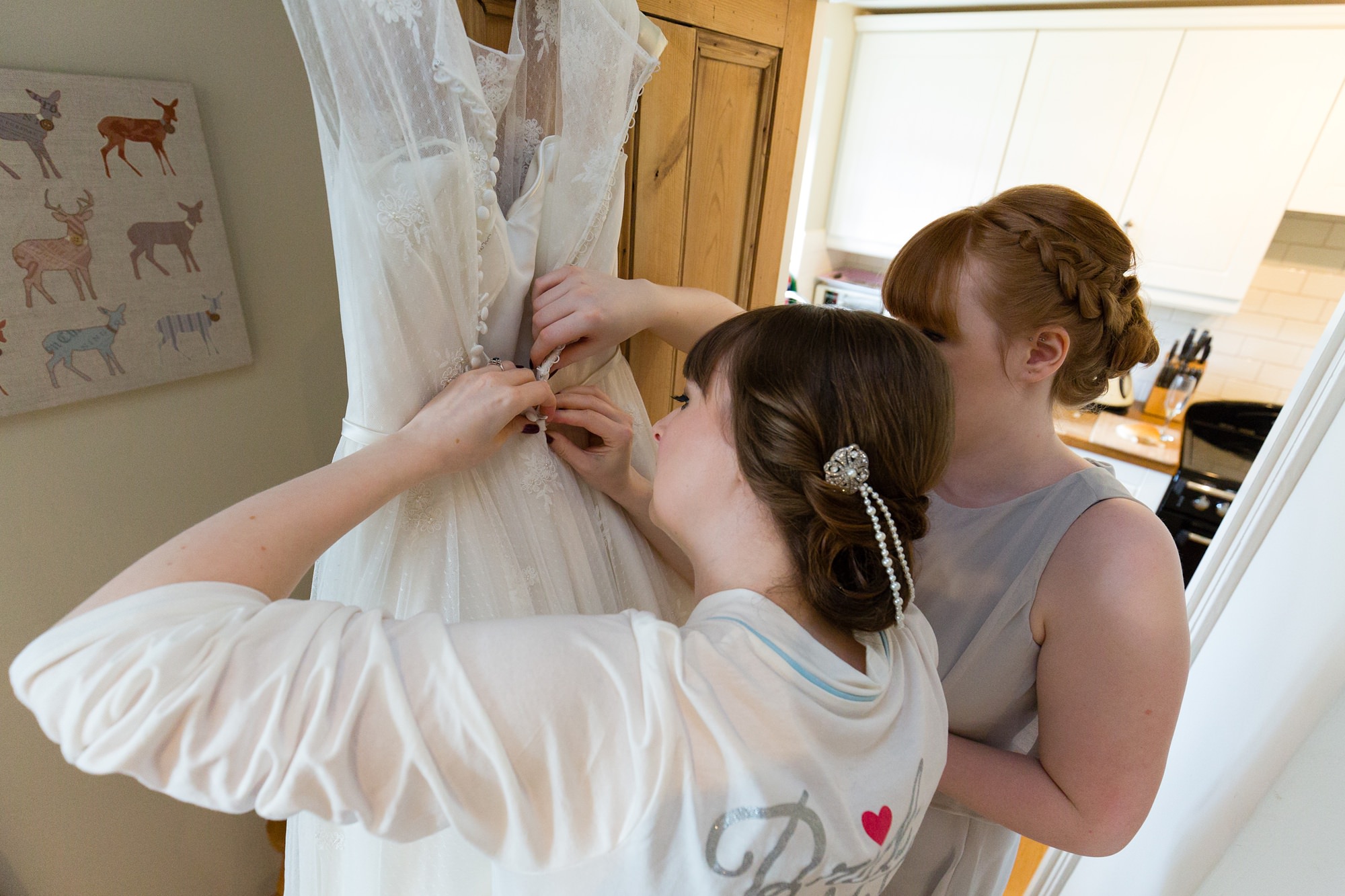 Yorkshire Wedding Photography Bride and sister unbuttoning wedding dress