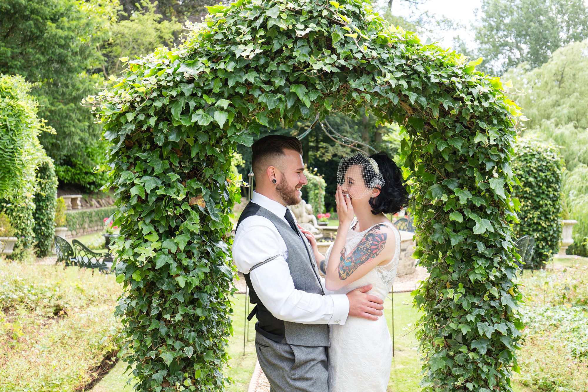 Tattooed wedding couple under the arch of ivy at Crab & Lobster