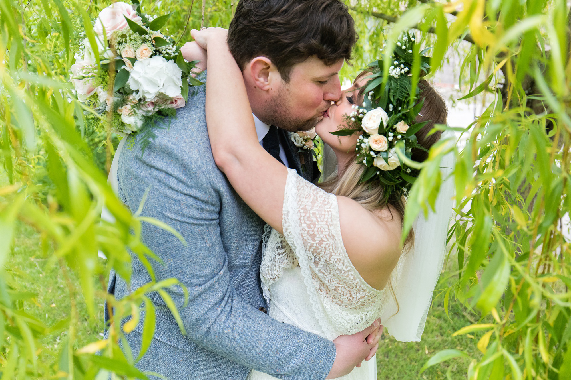 Bride and groom kiss under the willow tree at Villa Farm Wedding