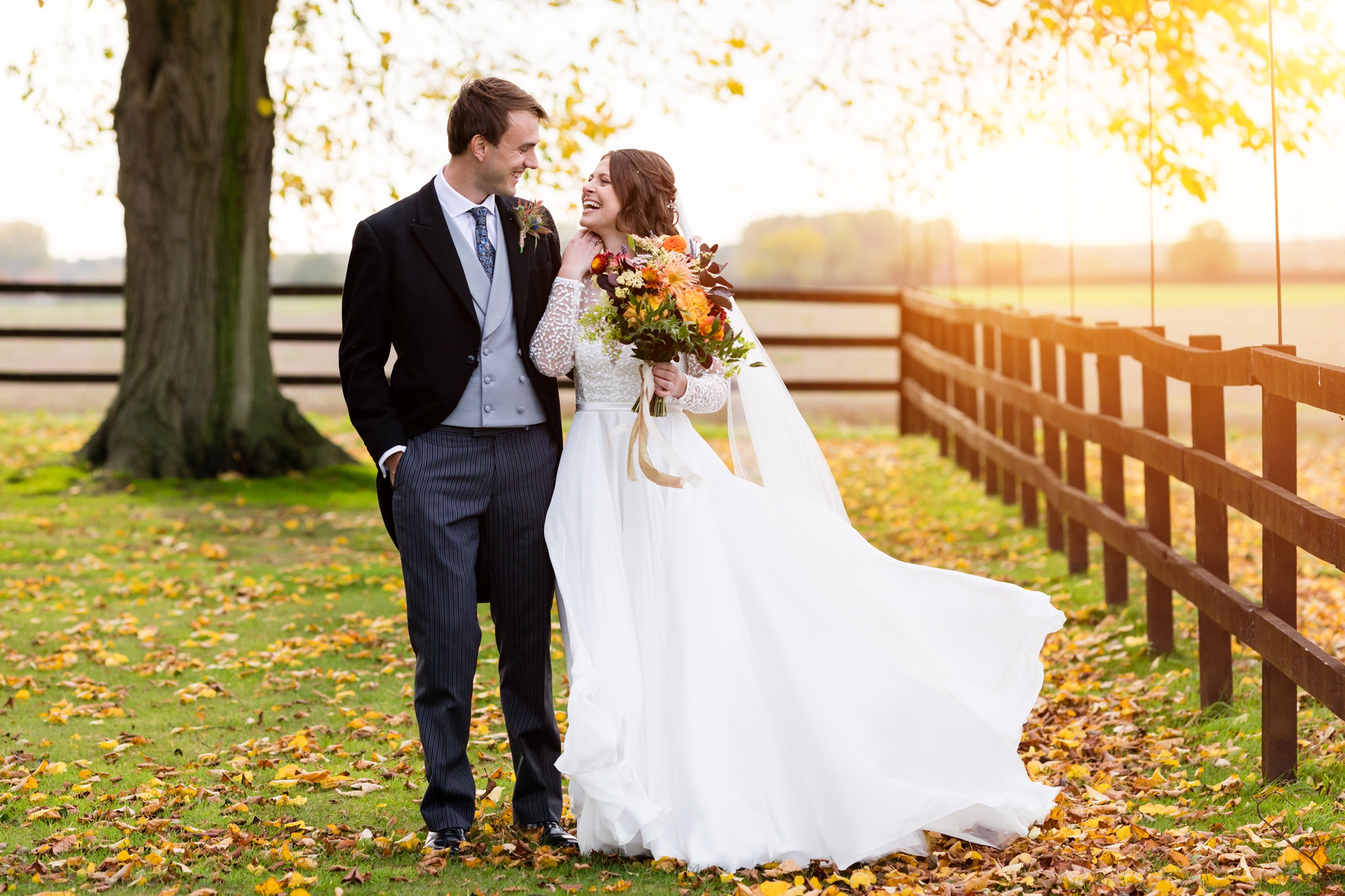 Bride and groom walk in the autumn light at Barmbyfield Barns