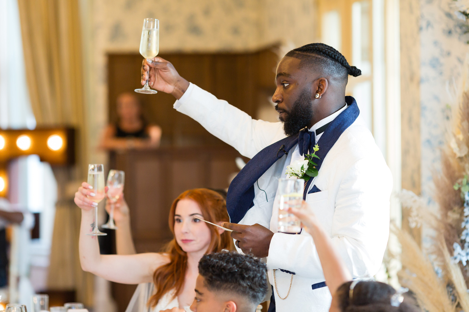Groom holds up toast glass at Rushpool Hall wedding