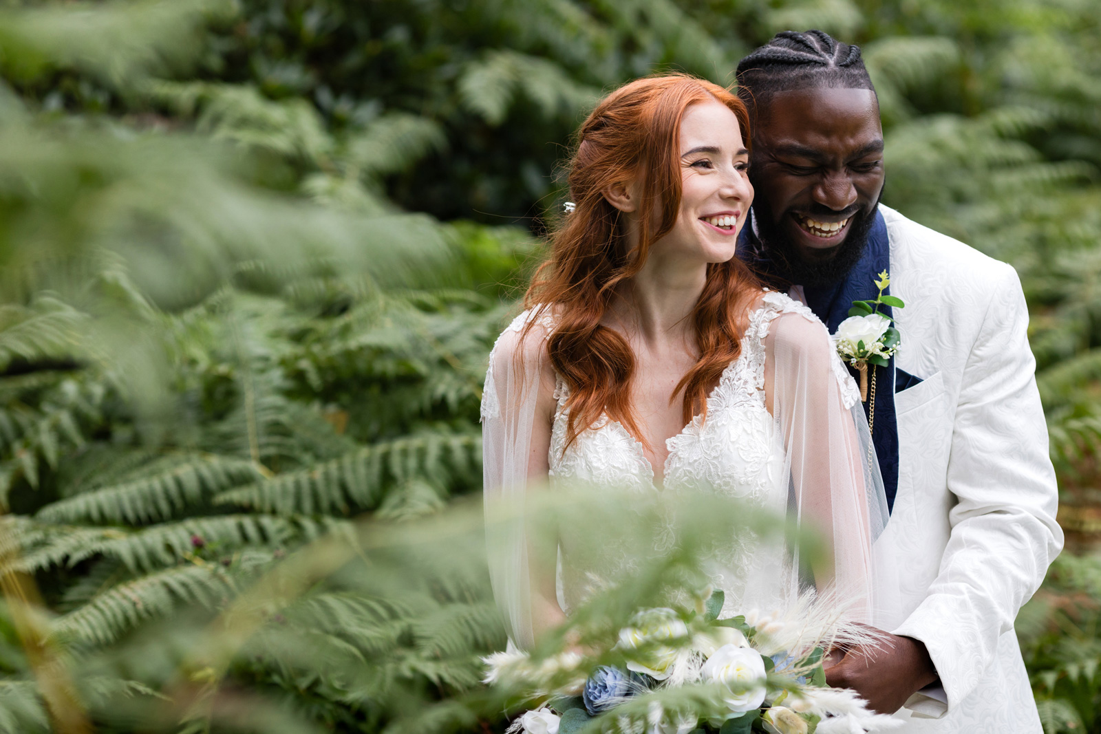 Groom laughs as bride smiles in couples photos at Rushpool Hall